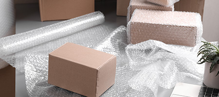 Cardboard Boxes Being Wrapped in Bubble Wrap