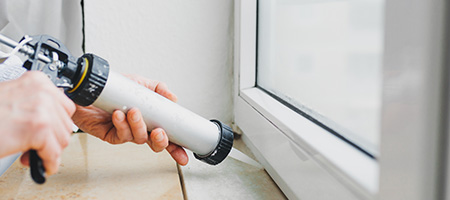 Homeowner Caulking Their Windows