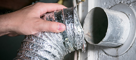 First-Time Homeowner Removing the Flexible Tubing of Their Dryer Vent to Clean it