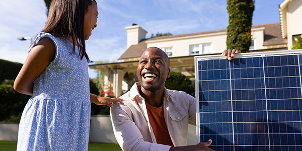 Father and Daughter Looking at Solar Panel Outside