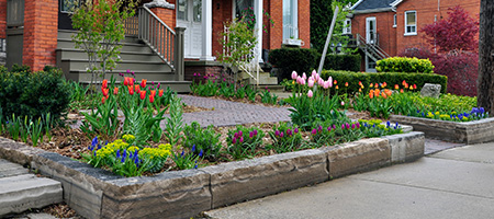 Front Yard With Stone Pathway and Flower Beds With Stone Walls