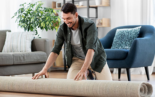 Man Decorating Living Room With a New Rug