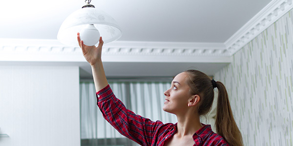 Woman Installing LED Light Bulb