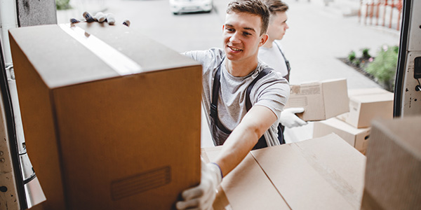 Man Loading Cardboard Boxes Into Moving Truck