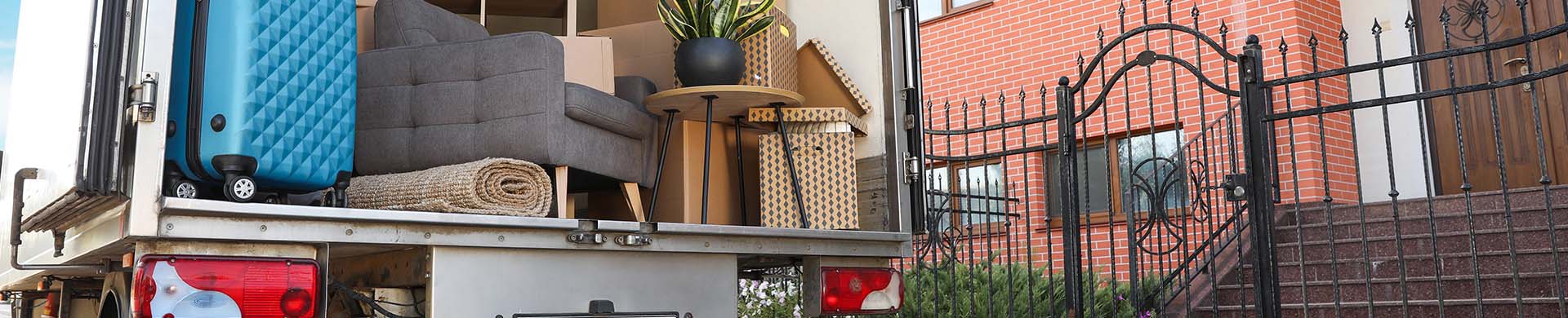 Back of Moving Truck Filled With Boxes Near House