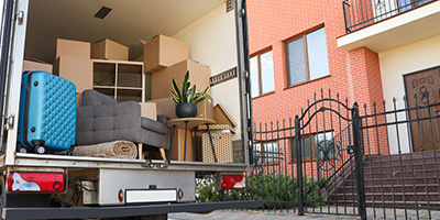 Back of Moving Truck Filled With Boxes Near House