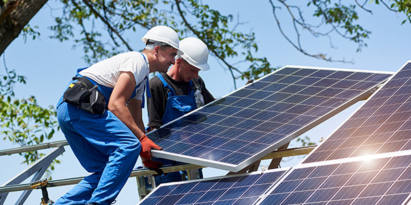 Two Men Installing Solar Panels on Roof