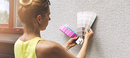 A homeowner deciding on the best exterior paint color to modernize their home. 