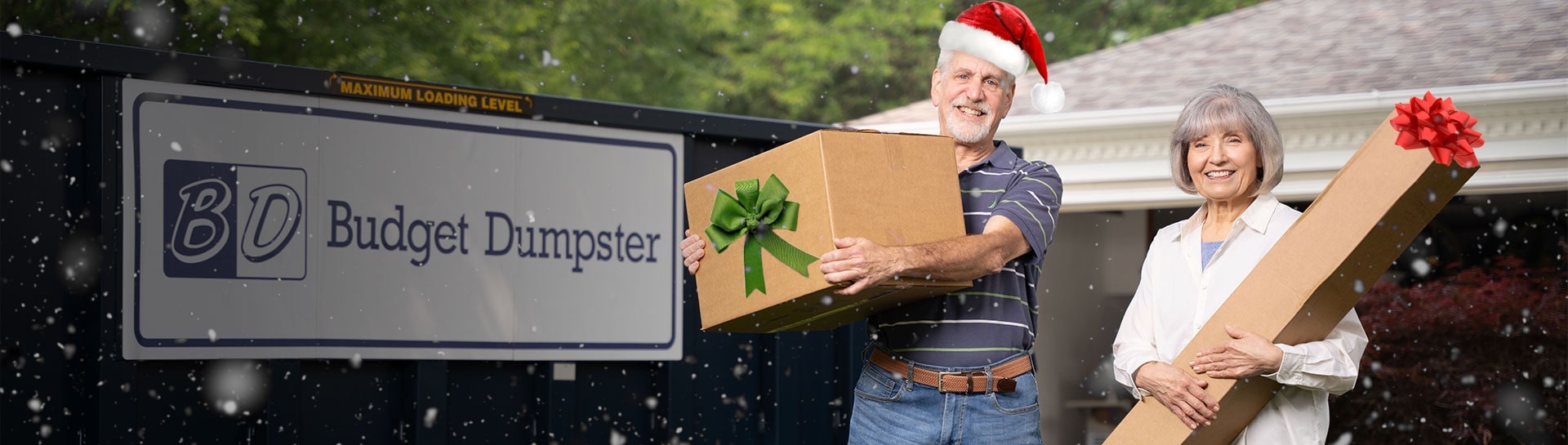 Couple Holding Boxes in Front of a Blue Budget Dumpster